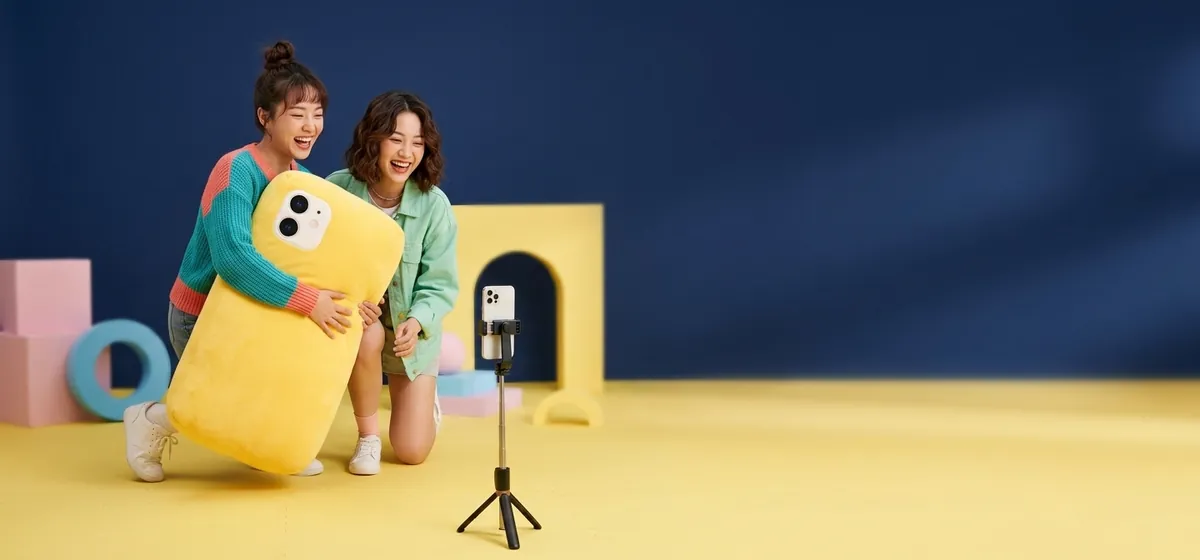 Two friends filming a short video on a phone / 两位朋友用手机拍短视频
